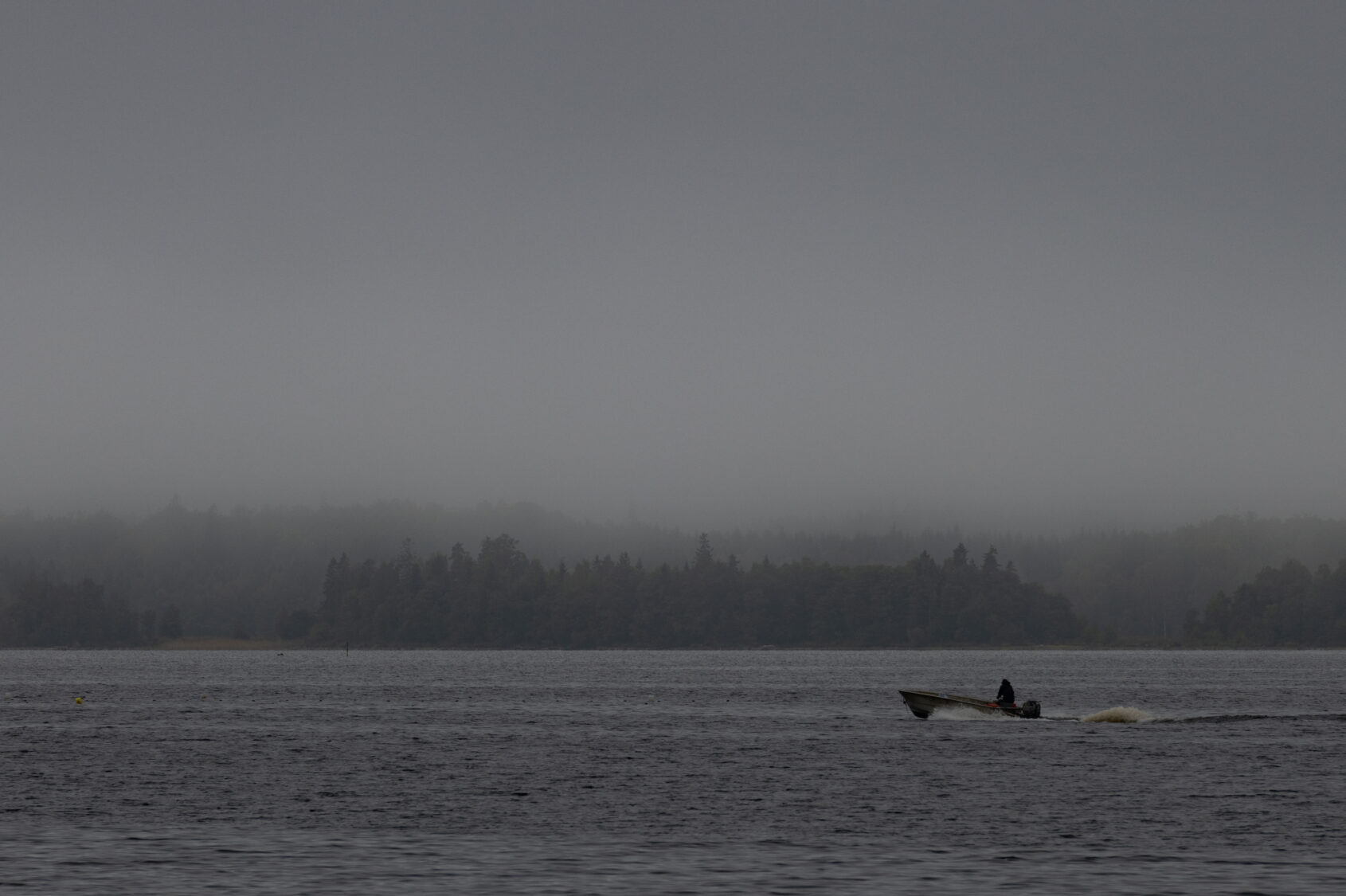 Motorbåt på Bolmen en grådisig dag.