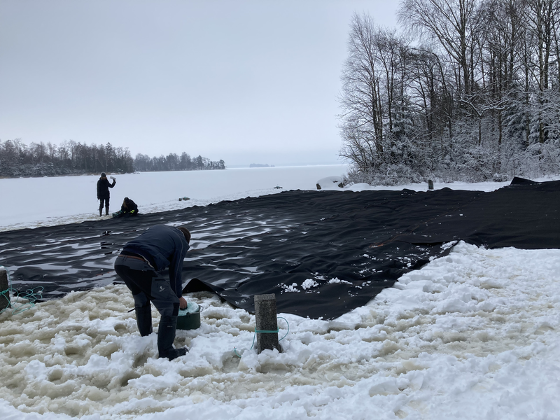 Täckduk läggs på isen på Bolmen