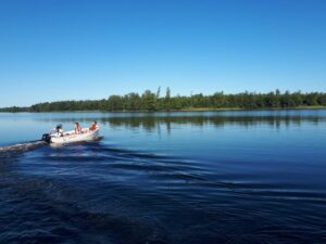 Forskarna i en båt på Bolmen, på väg ut till mesokosmerna.