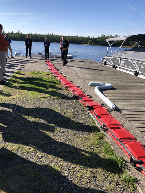 På en brygga ligger en lång röd flytläns och en lite kortare vit absorbtionsläns.
